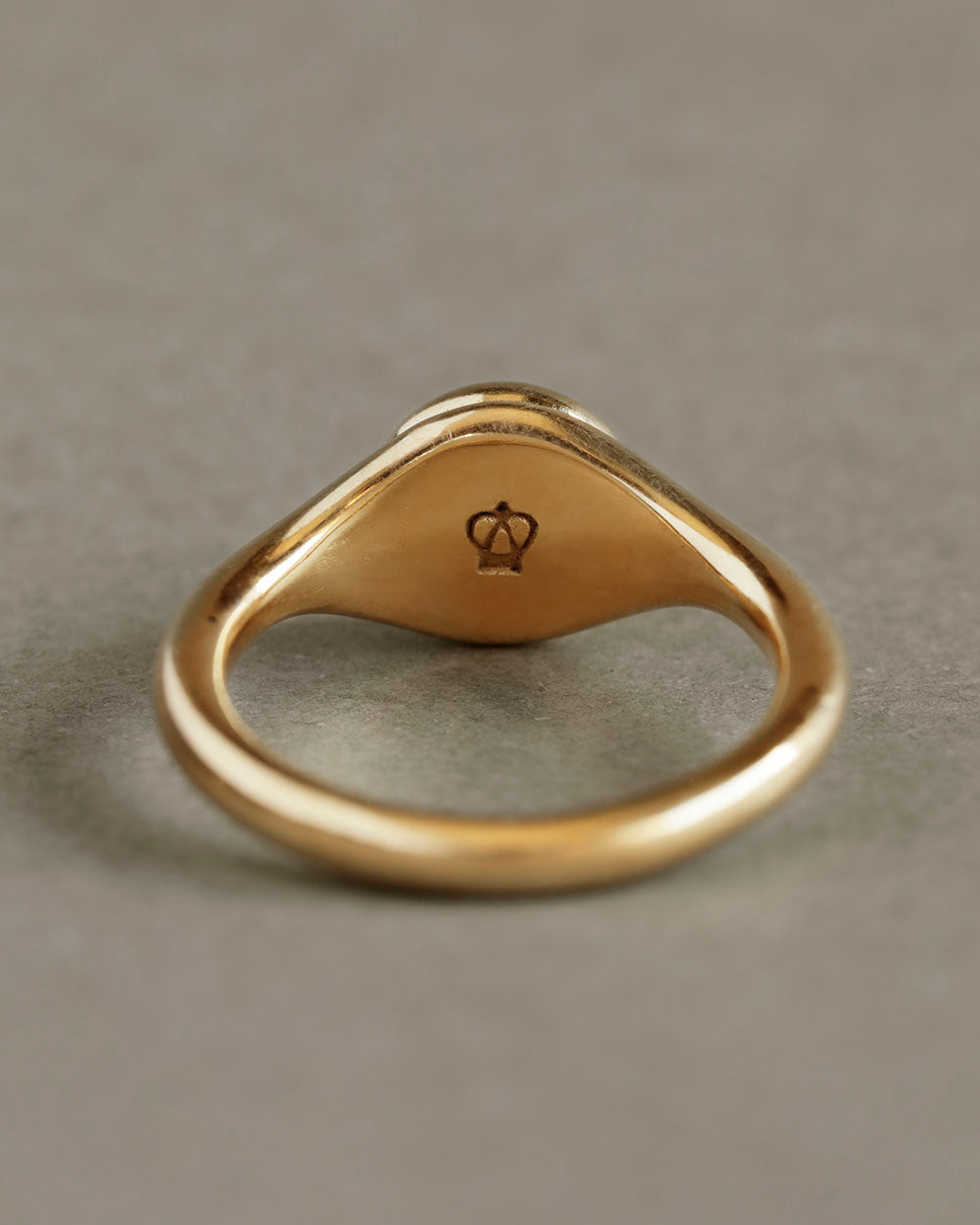 Solid 18k yellow gold band with soft button circle atop elegant signet style ring