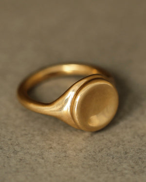 Large 18k yellow solid gold signet style ring with a large soft concave button circle atop the signet.