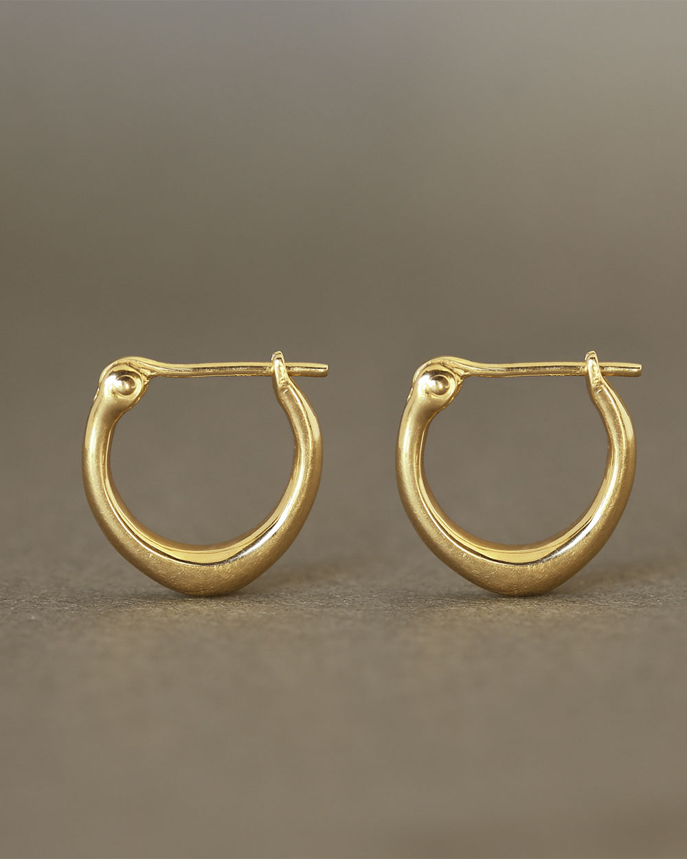 Pair of solid 18k yellow gold hoop earrings with a soft dome shape. Part of the George Rings Capitol Collection.