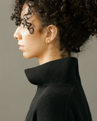woman wearing pair of solid 18k yellow gold hoop earrings with a soft dome shape, paired with Gold Dot Studs. Part of the George Rings Capitol Collection.