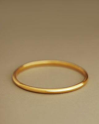 Gold bracelet on a beige background