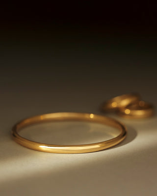 Solid 18k yellow gold round bangle by George Rings. Dominus Bangle. Not hollow.