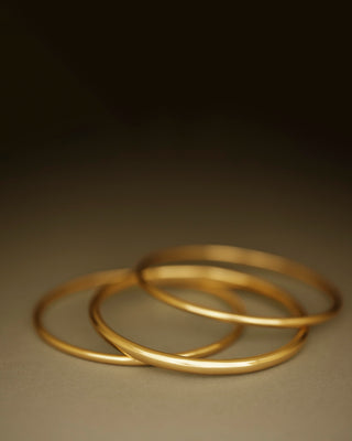 Solid 18k yellow gold round bangle by George Rings. Dominus Bangle. Not hollow.