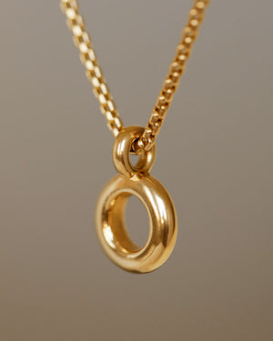 Solid 18k yellow gold donut pendant hanging on a 14k gold box chain. Soft and heavy.