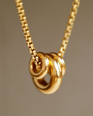 Three solid heavy soft 18k yellow gold donuts hanging on a 14k gold box chain