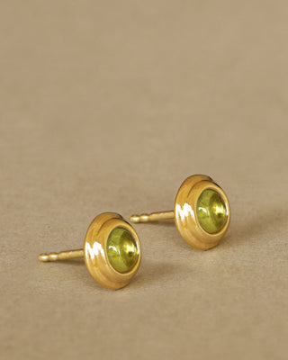duchess studs in peridot by george rings. solid 18k yellow gold round studs with peridot cabochons in the midldle.