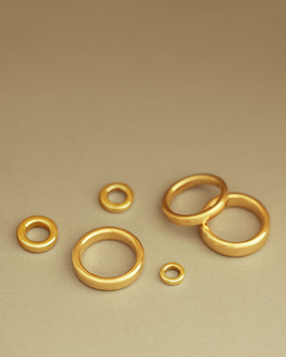 Baby Essential Bands laid next to Essential Band Mid and Essential Band Grand for comparison by George Rings solid 18k yellow gold pendant rings