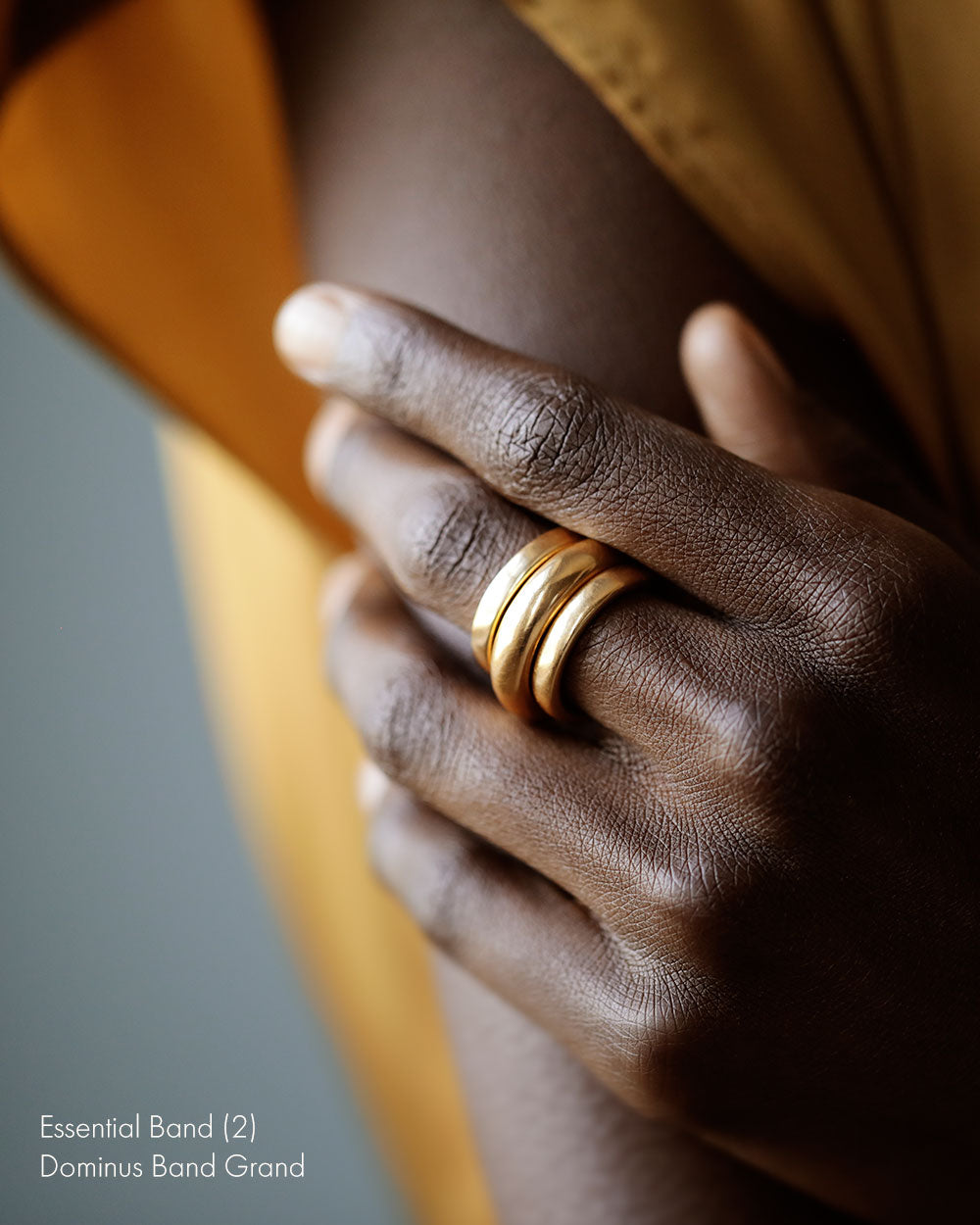 Young black woman wears Large 18k solid yellow gold donut ring on her middle finger.