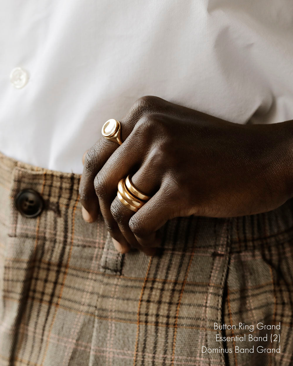 Cropped image of black woman's hands wearing gold rings. Large 18k yellow solid gold signet style ring with a large soft concave button circle atop the signet.