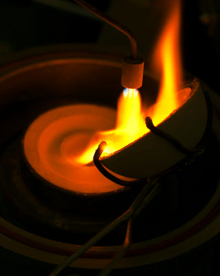 molten gold being poured into lost wax casting flask
