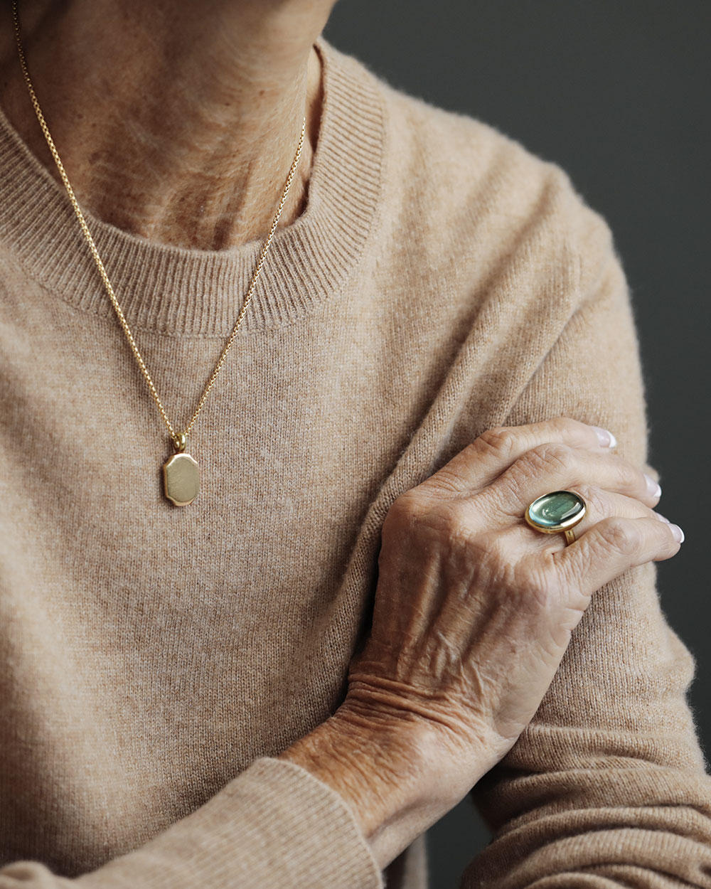 Older woman wearing Lago di Como Estate Ring by George Rings Blue Green Tourmaline Cabochon Cocktail ring oval solid 18k gold
