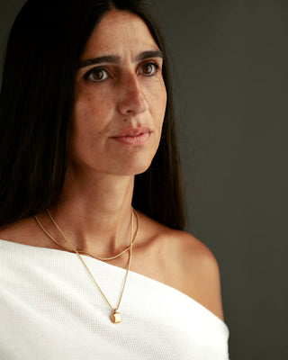 Solid 18k yellow gold pillow puff pendant hanging from a solid 14k yellow gold box chain. Pillow Pendant by George Rings.