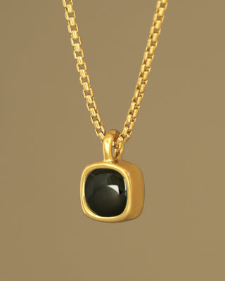 A moody black green tourmaline rounded square gem inside a solid 18k yellow gold bezel. Sovereign Pendant by George Rings.