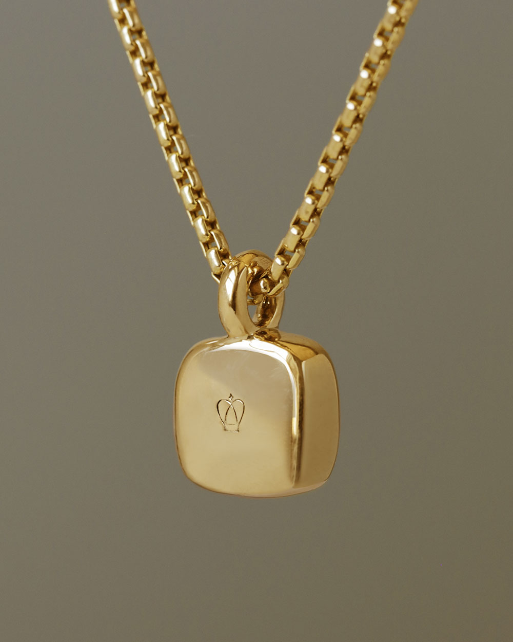 Rounded square gem inside a solid 18k yellow gold bezel, hanging on a solid 14k yellow gold box chain. Sovereign Pendant by George Rings.