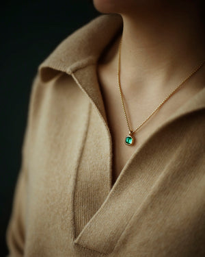 A juicy green lab emerald rounded square gem inside a solid 18k yellow gold bezel, hanging on a solid 14k yellow gold box chain. Sovereign Pendant by George Rings.