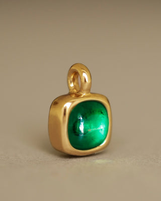 A juicy green lab grown emerald rounded square gem inside a solid 18k yellow gold bezel, hanging on a solid 14k yellow gold box chain. Sovereign Pendant by George Rings.