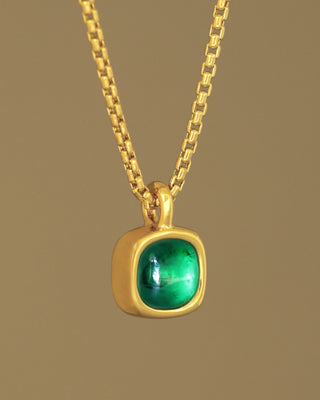 A juicy green lab grown emerald rounded square gem inside a solid 18k yellow gold bezel, hanging on a solid 14k yellow gold box chain. Sovereign Pendant by George Rings.