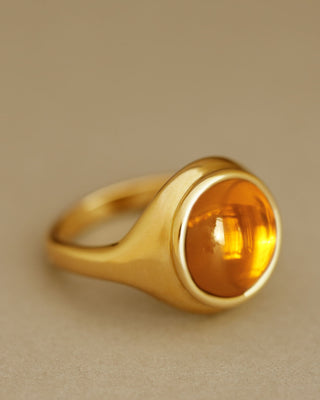 Golden large round cabochon citrine gem sits inside large round 18k solid yellow gold signet ring. The Monarch by George Rings.
