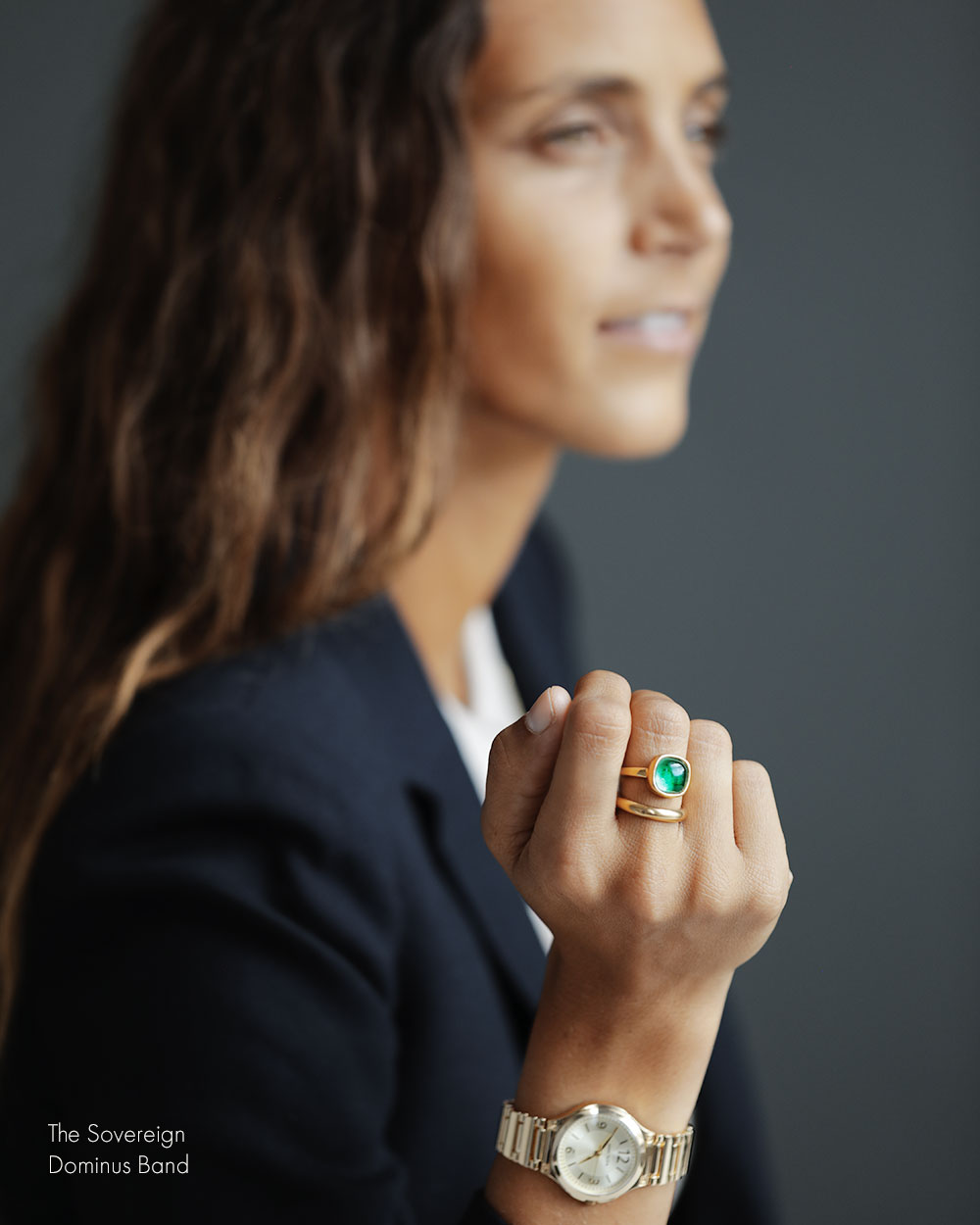 Woman in navy blazer wearing The Sovereign by George Rings emerald cabochon solitaire ring wedding engagement ring cast in solid 18k yellow gold