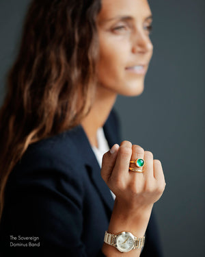 Woman in navy blazer wearing The Sovereign by George Rings emerald cabochon solitaire ring wedding engagement ring cast in solid 18k yellow gold